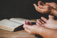 Group of people holding hands praying worship believe