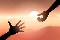 Silhouette of hands reaching out to help